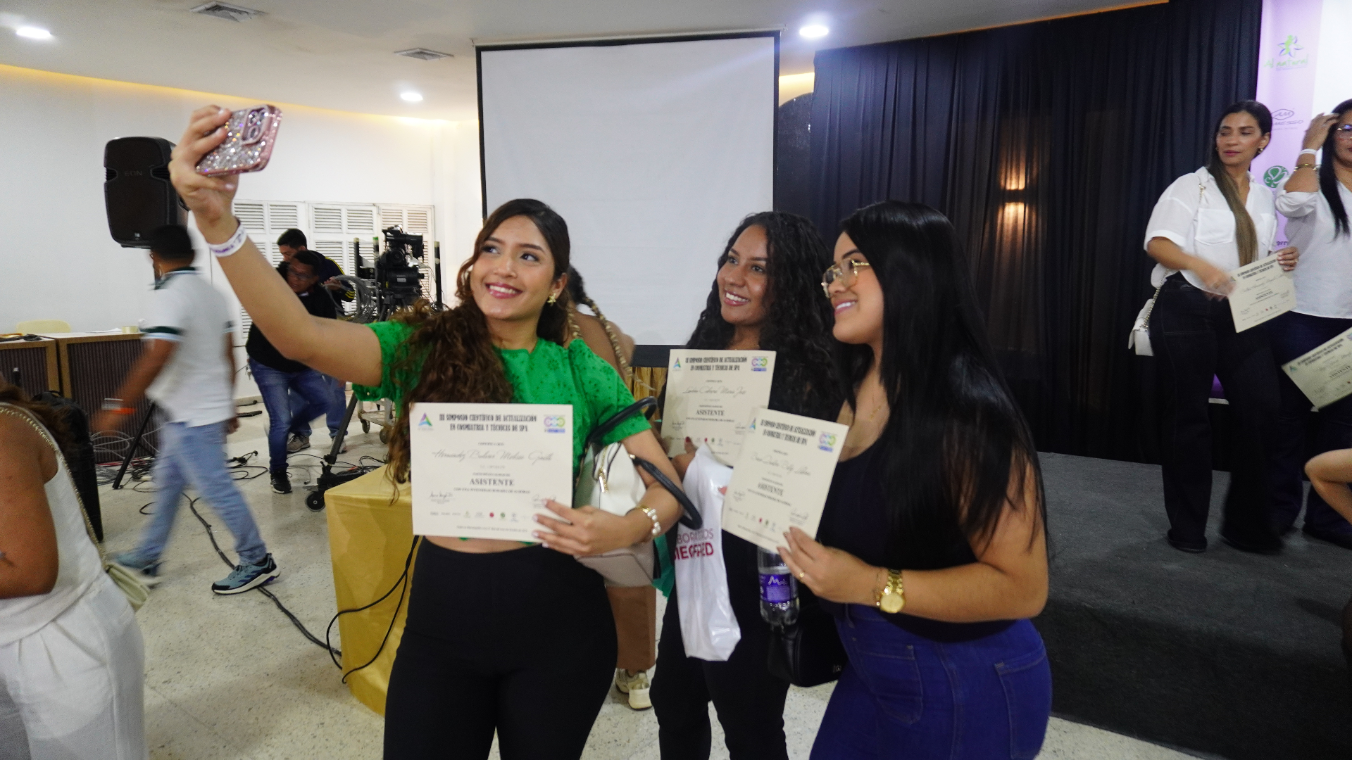 Asistentes tomándose una fotografía con sus certificados al cierre del evento